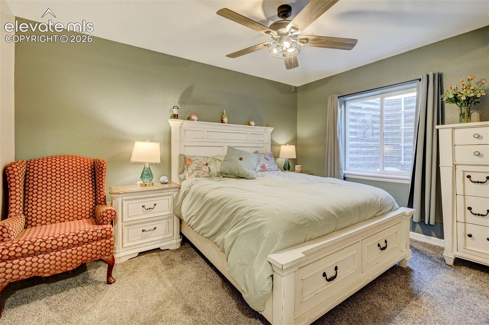 Room featuring wall-to-wall carpeting, a ceiling fan with integrated lighting, and a single-pane sliding window