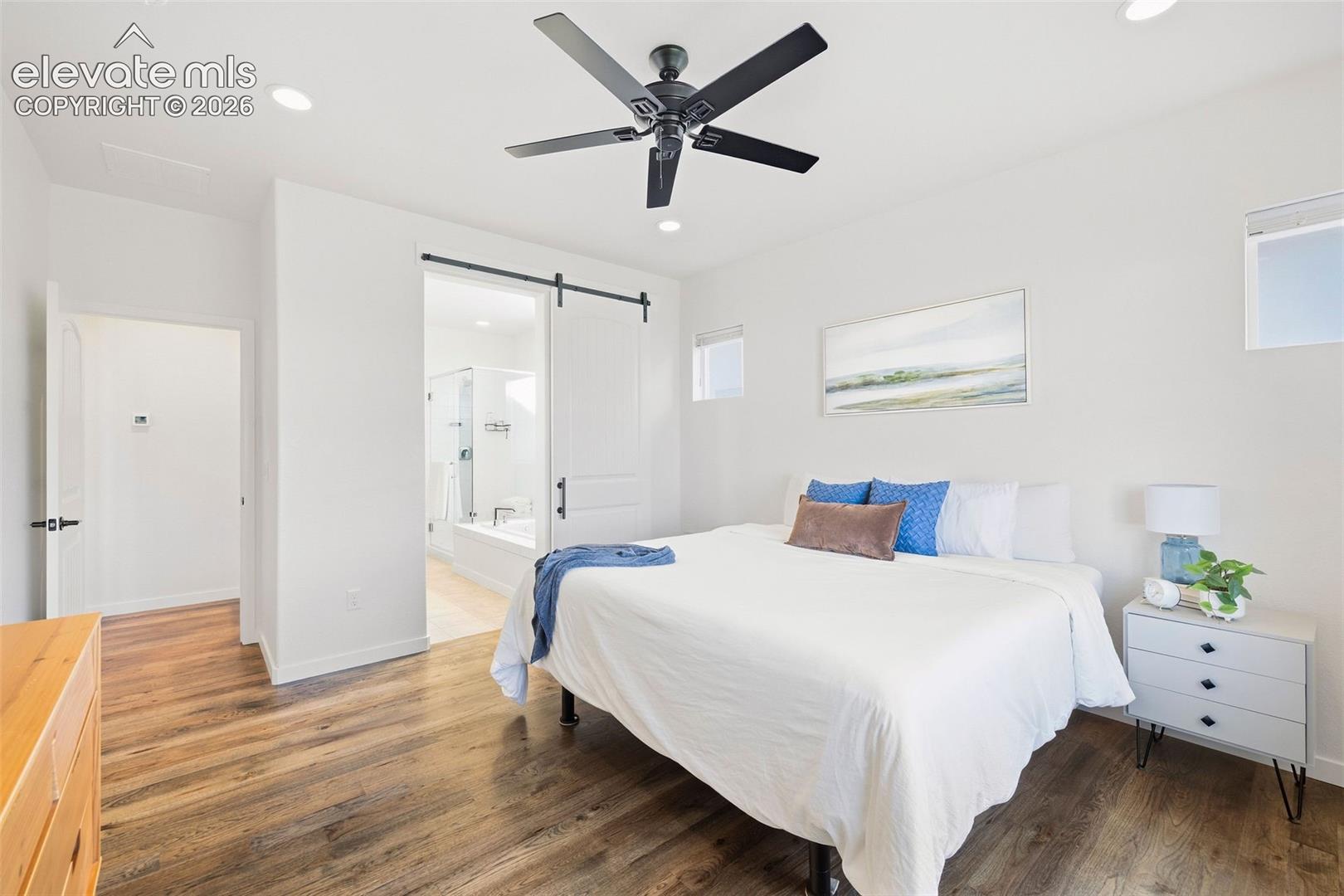 A barn door keeps the primary bedroom and ensuite bath separate. 
