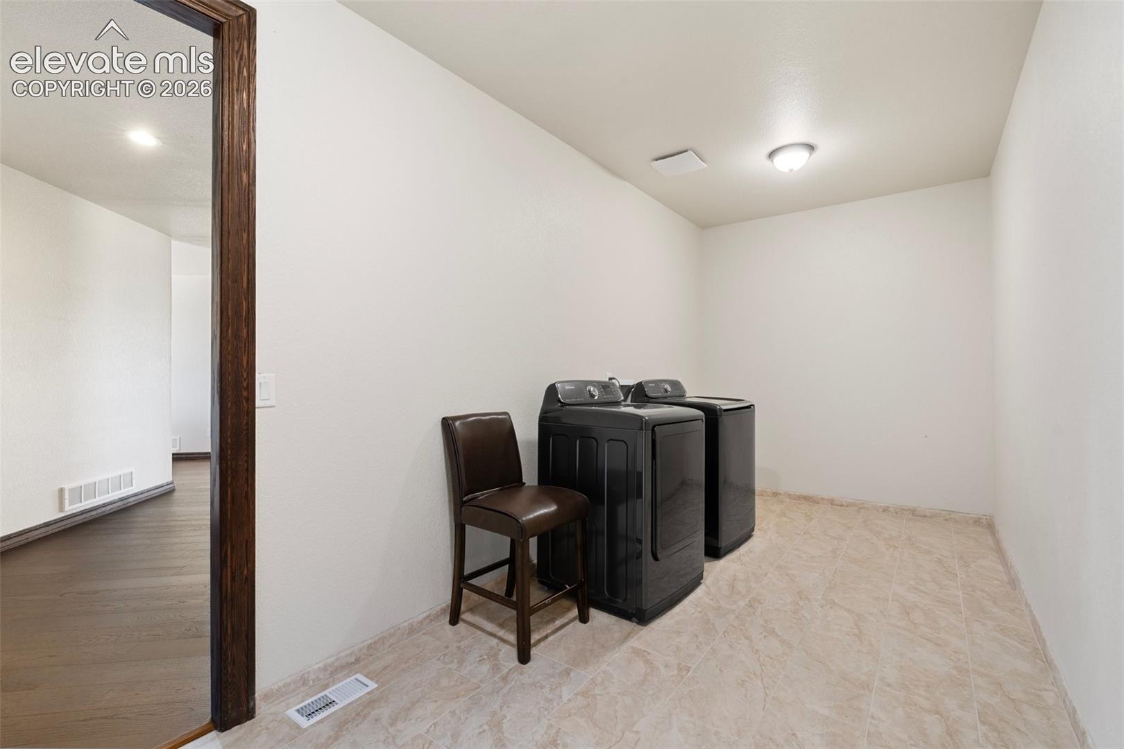 Dedicated laundry area featuring ceramic tile flooring, a recessed ceiling light fixture, and white painted walls