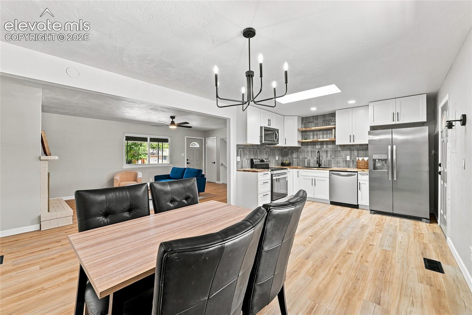 Updated kitchen with white cabinetry and stainless steel appliances