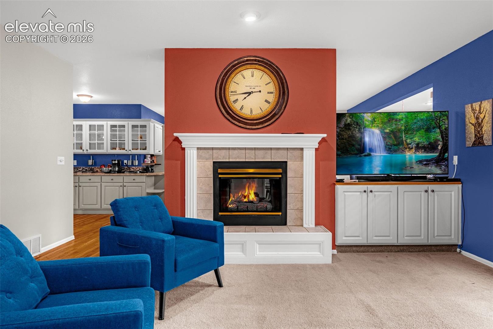 Fireplace with a tile surround and white mantel, flanked by built-in cabinetry with a wood countertop