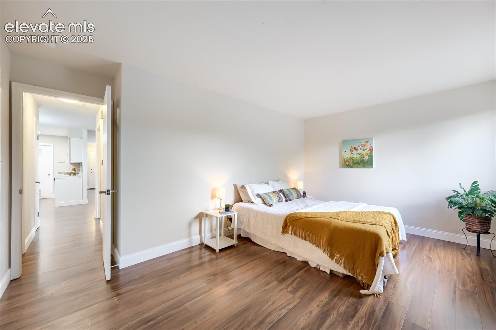 Large primary bedroom with new floors, baseboard and paint