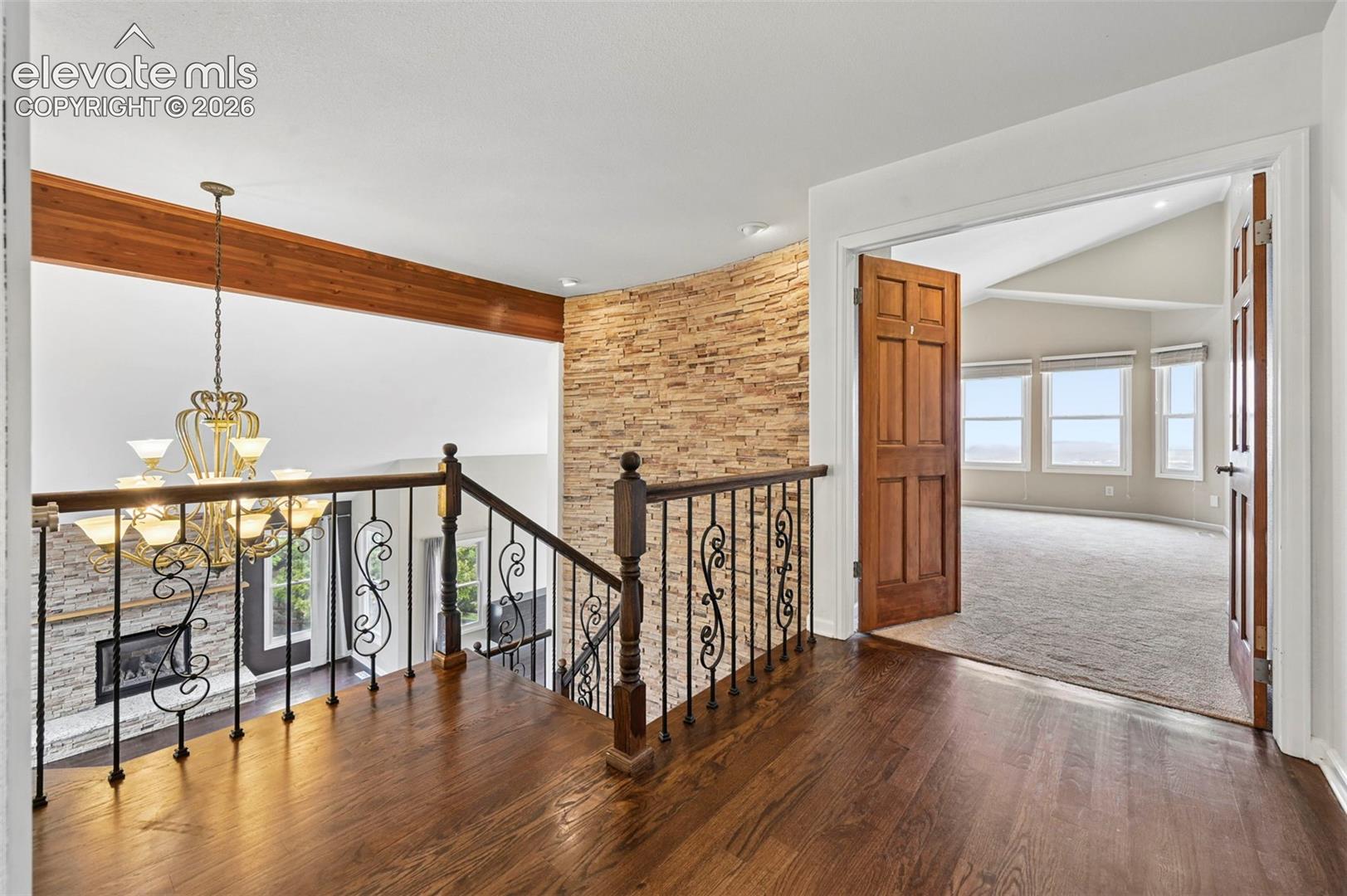 Upper loft area, looking into primary bedroom that is tucked behind classic double doors, overlooking the city!! 