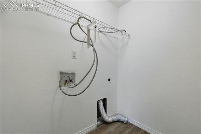 Laundry area featuring dark wood finished floors, hookup for an electric dryer, baseboards, and washer hookup