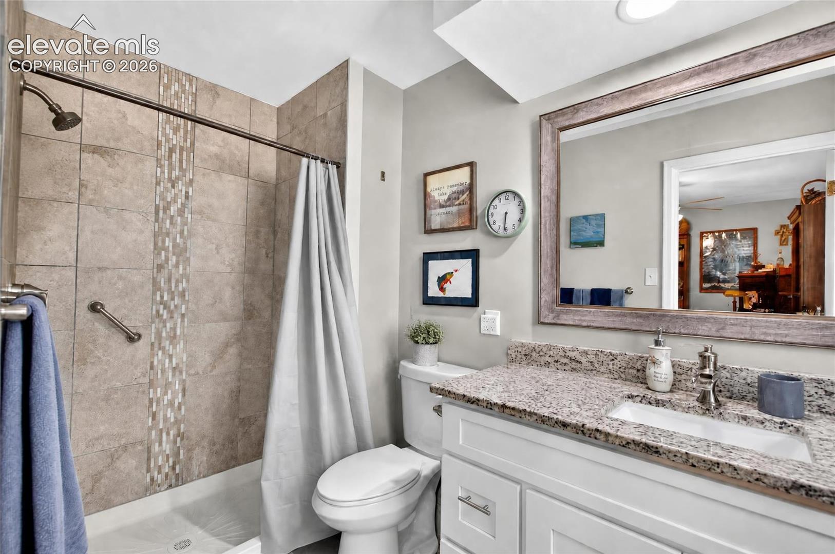 Bathtub with subway tile surround, decorative tile inlay, and grab bar