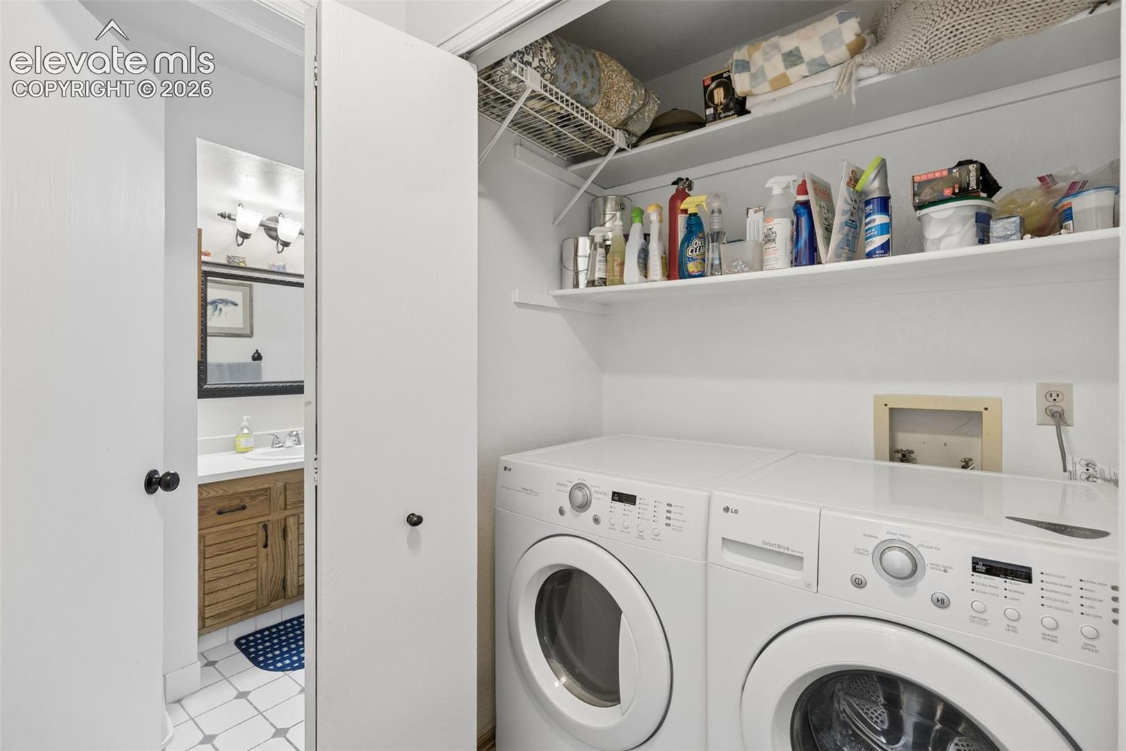 Laundry closet with built-in shelving, a white countertop, and a utility outlet