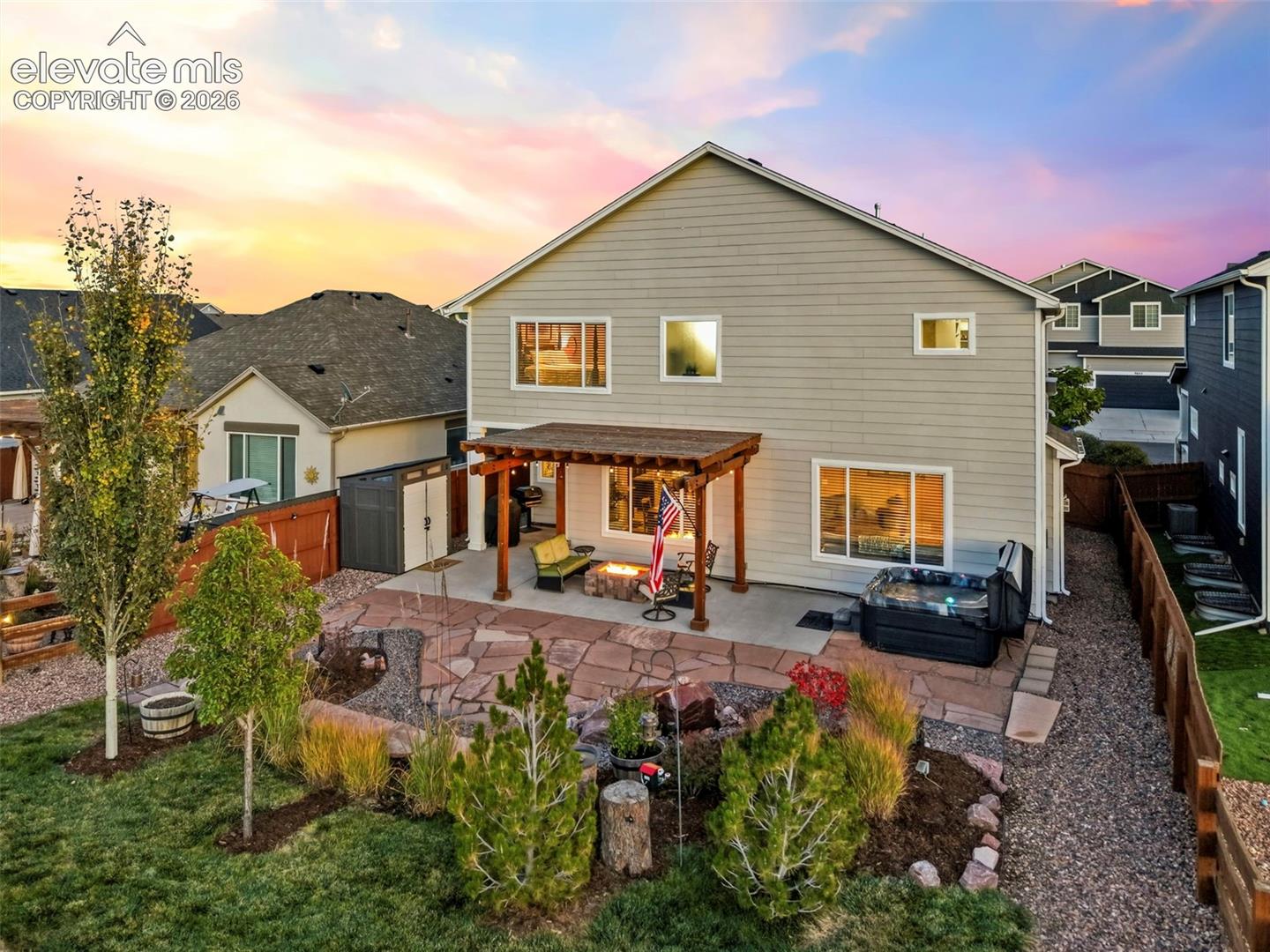 The stunning backyard offers a flagstone patio, built-in gas firepit, pergola, and bubbling rock water feature, making it the perfect outdoor retreat