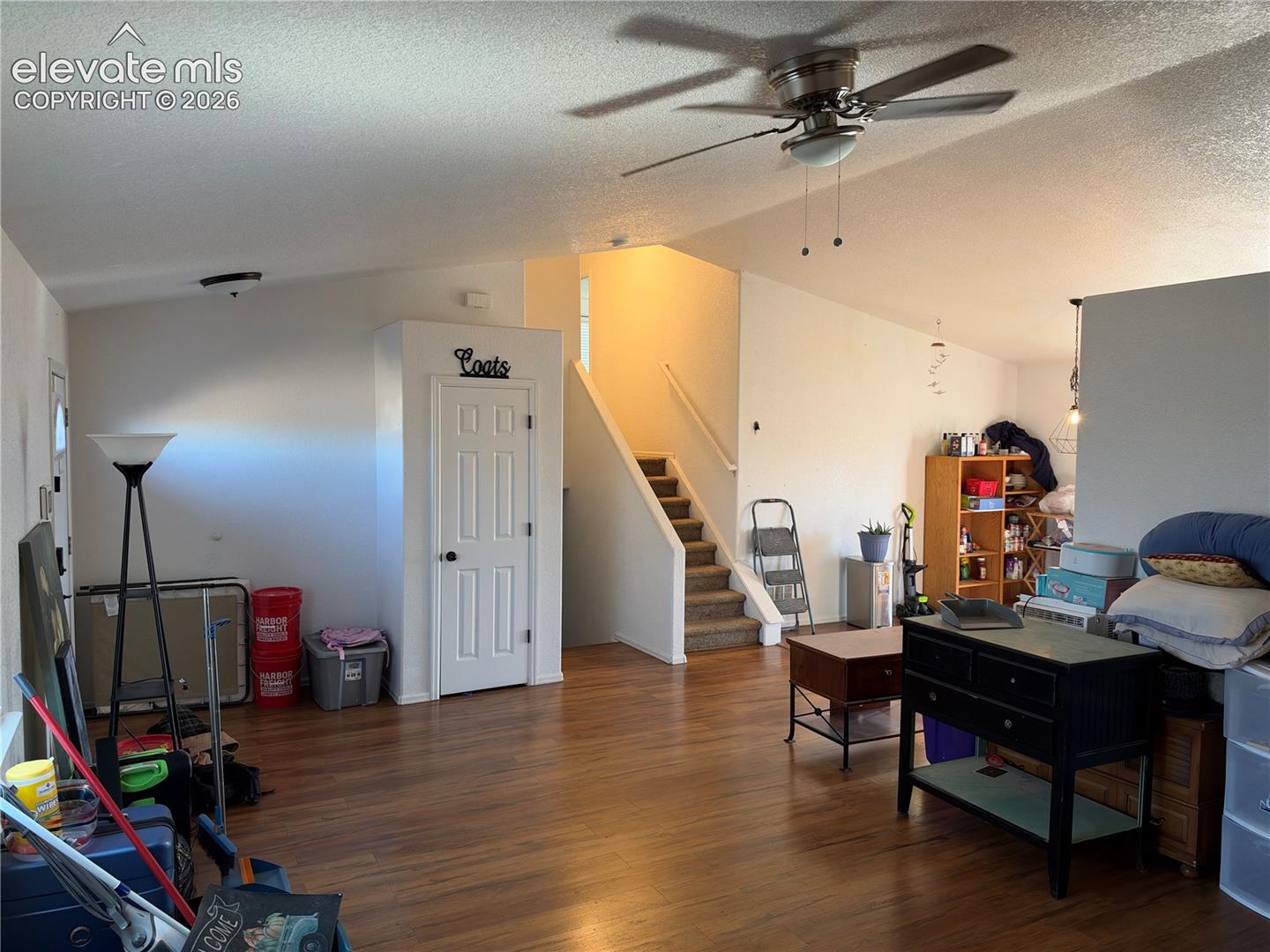 Vaulted ceilings, wood-finish flooring, and a ceiling fan
