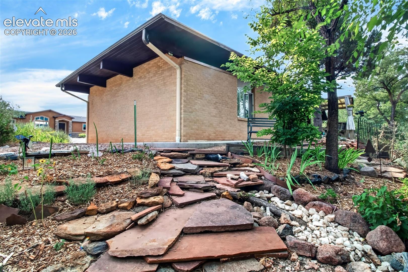 Looking at the side of the home fromo ne of the flagstone walkways