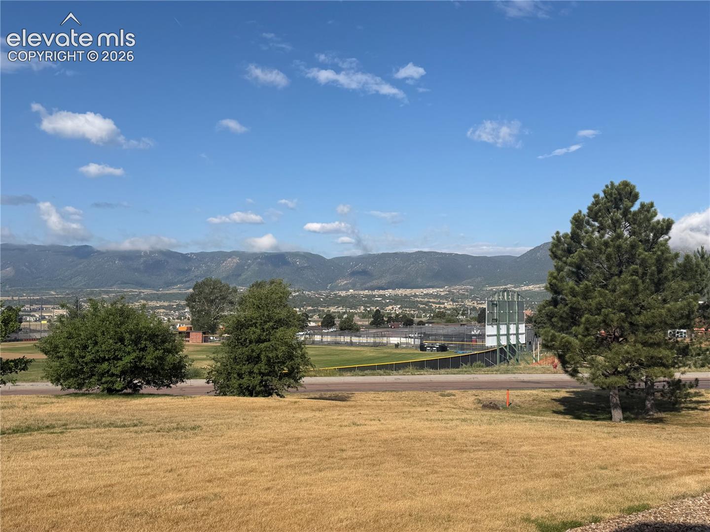 Expansive mountain backdrop with scattered clouds