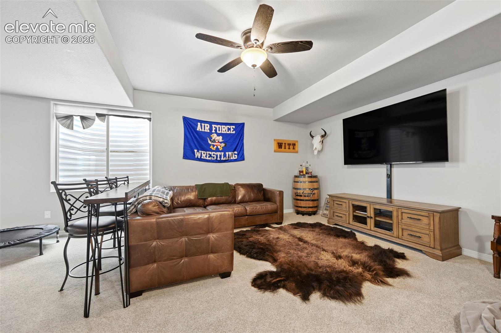 Neutral-toned room featuring a coffered ceiling and carpeted flooring