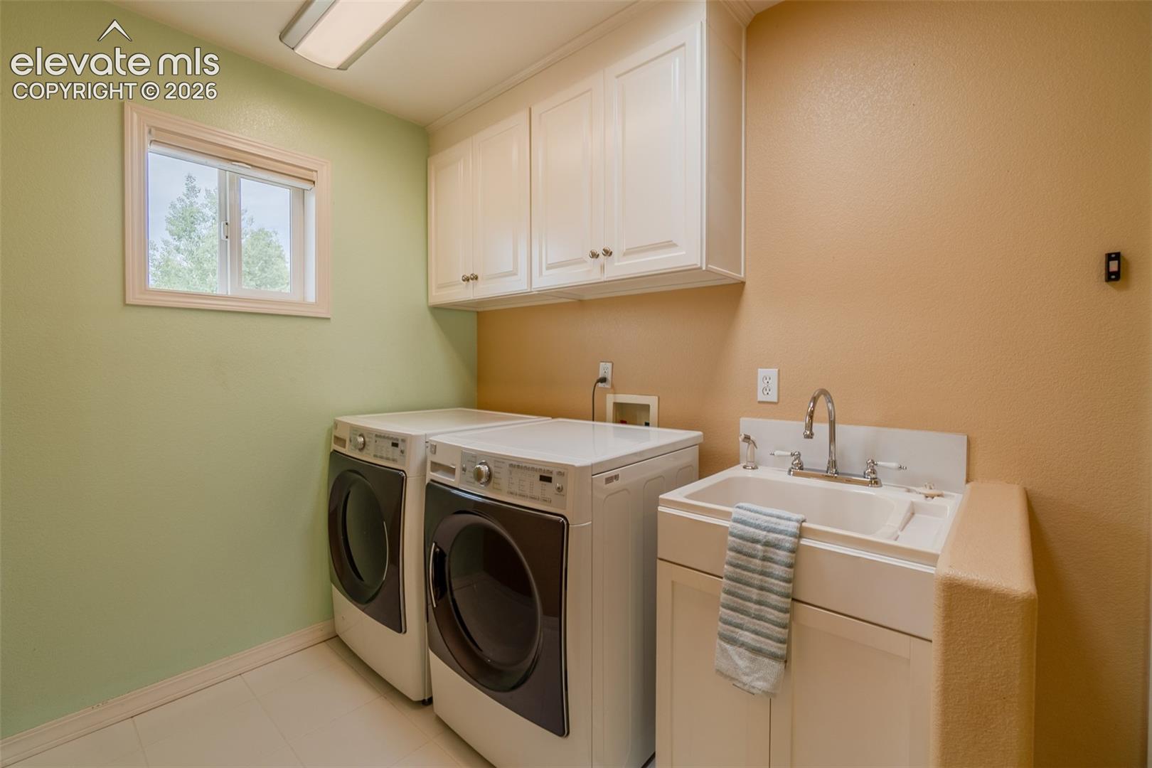 Convenient main-level laundry room with built-in cabinetry for extra storage and organization.
