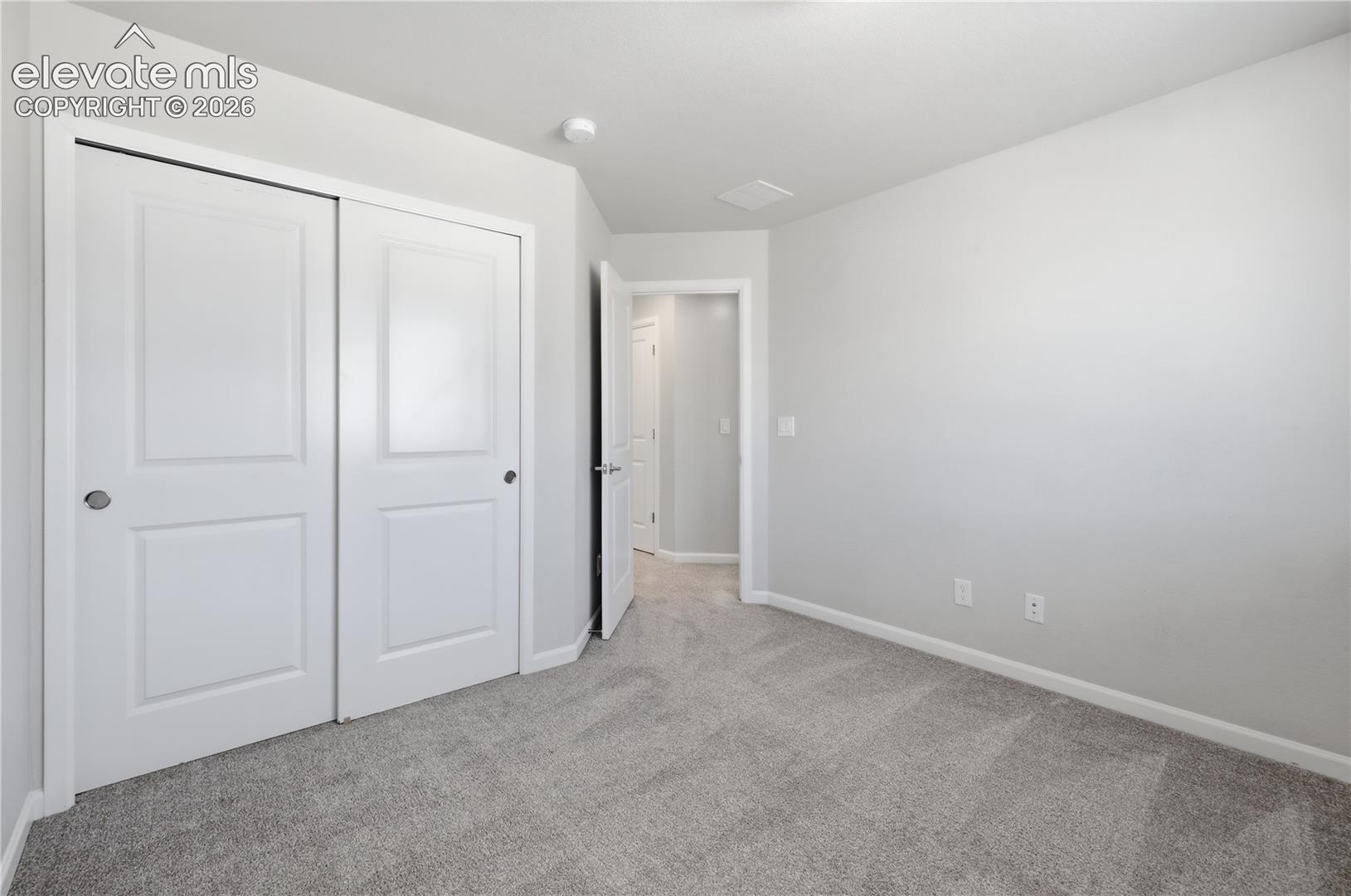Room featuring neutral gray carpeting and light gray wall paint