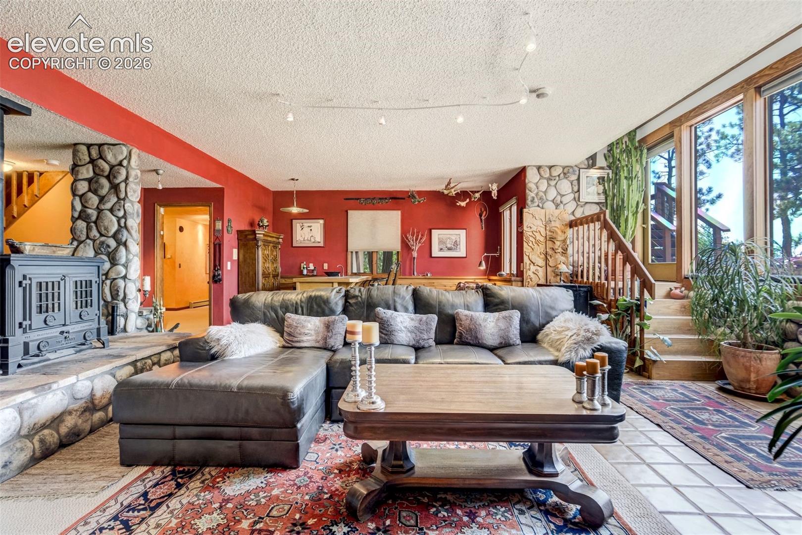 Family room boasts about 18-20' high of river rock accents from basement to main level living room ceiling 