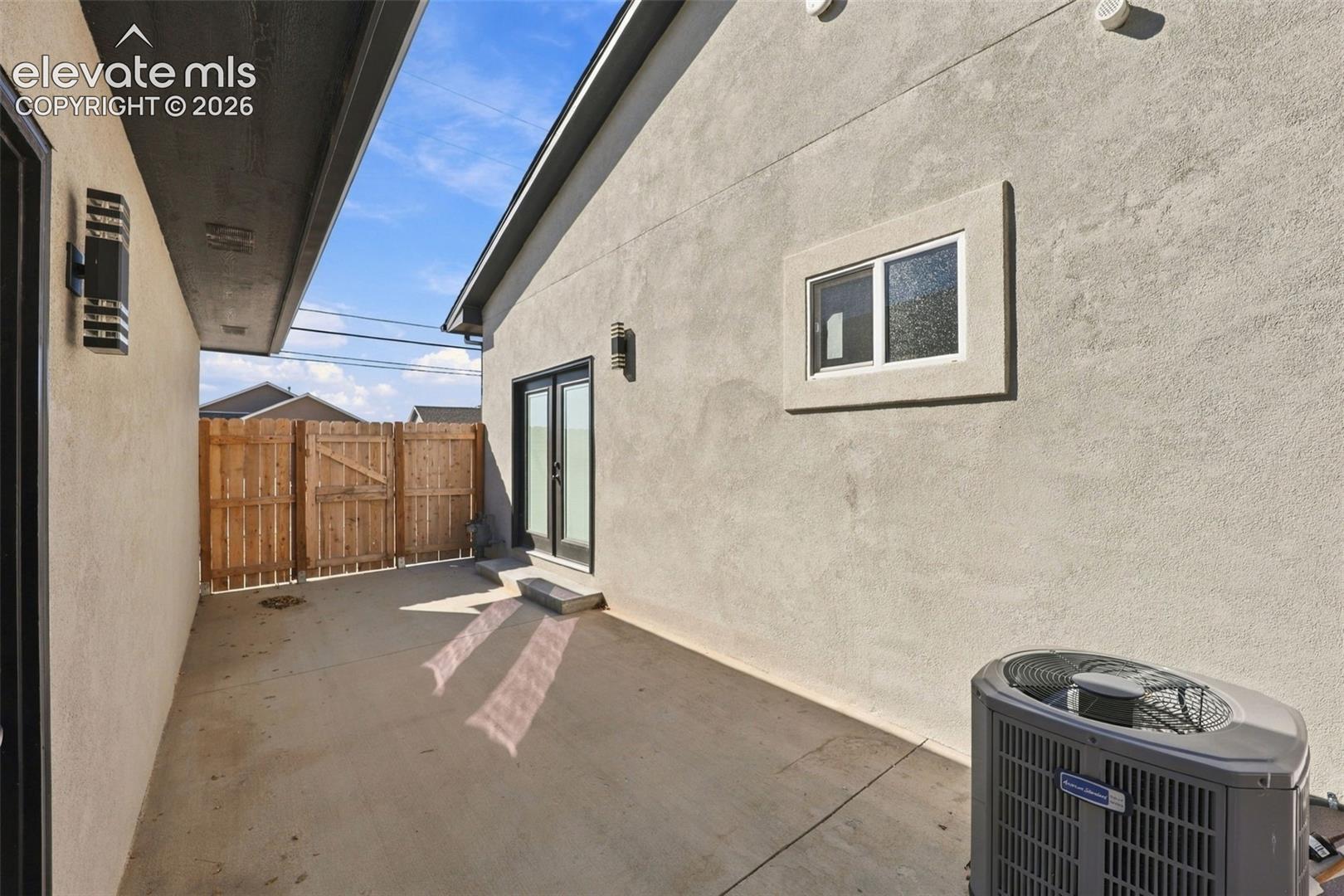 Poured concrete walkway with a wood fence and dual-pane window