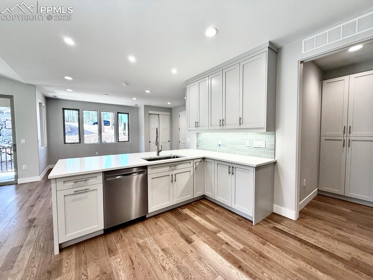 Full-sized Gourmet Kitchen with Quartz Countertops, Upper Cabinets to the Ceiling, Under-cabinet lighting., Induction Range, Included Stainless Still Fridge, and Wood Flooring.