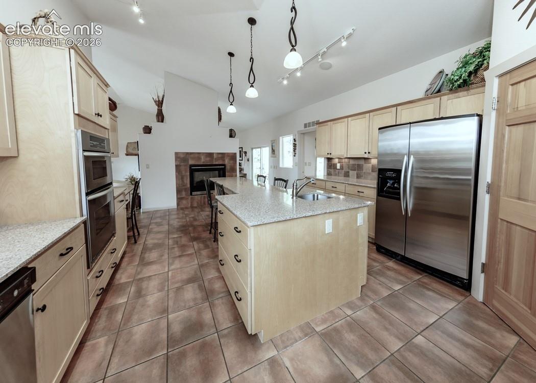 Warming drawer, dual oven, convection microwave, country sink, prep sink, and a 5-burner gas cooktop.