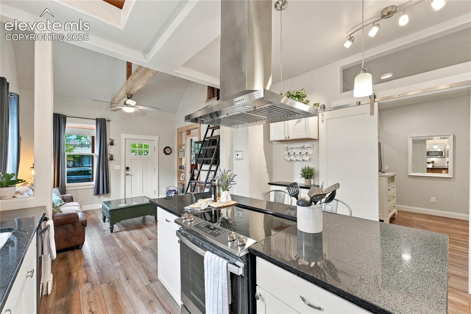 Kitchen with large island, SS hood, secondary bedroom coffered ceilings. Second bedroom suite is shown to the right. 
