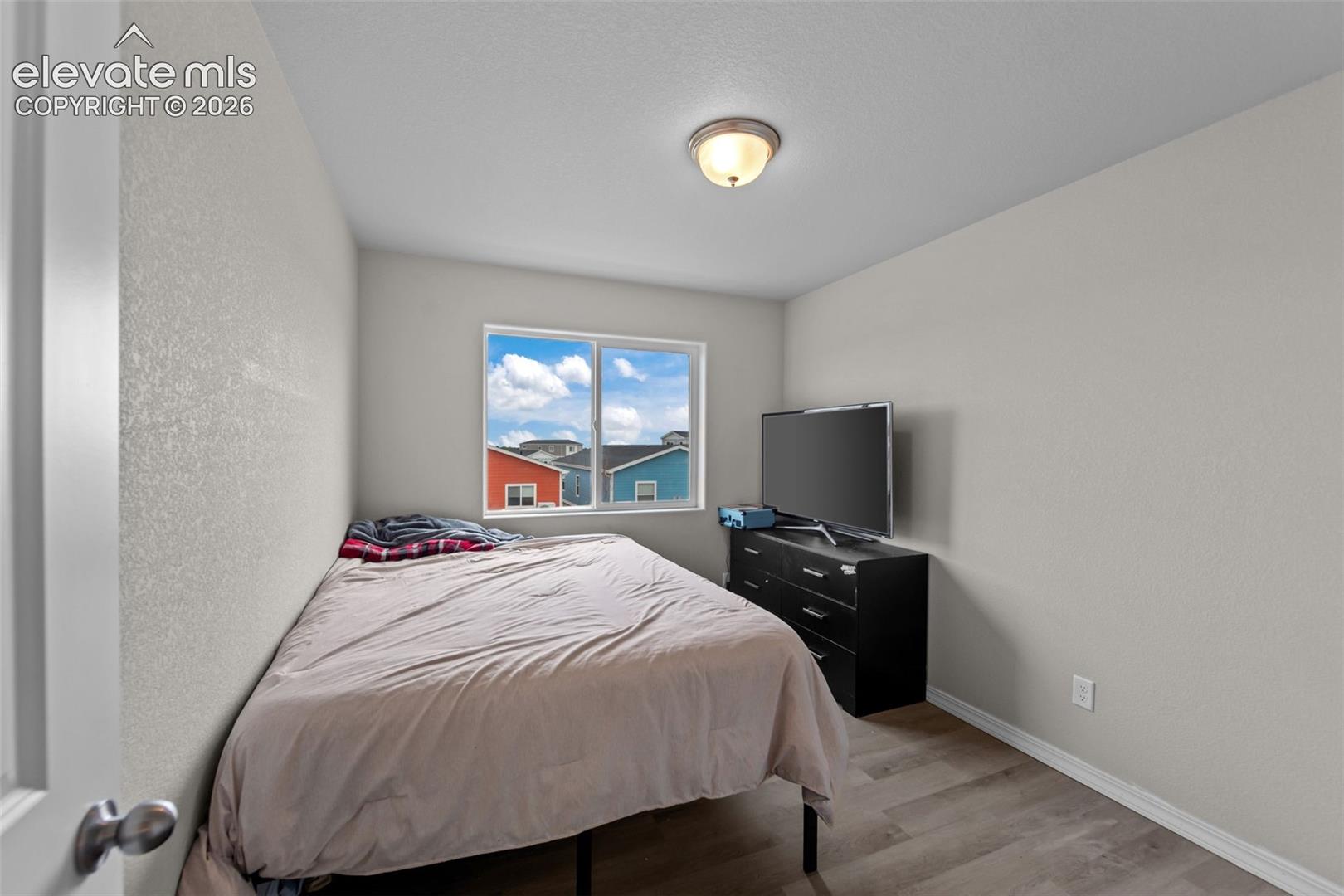 Recessed lighting, wood-finish flooring, and a window with white trim