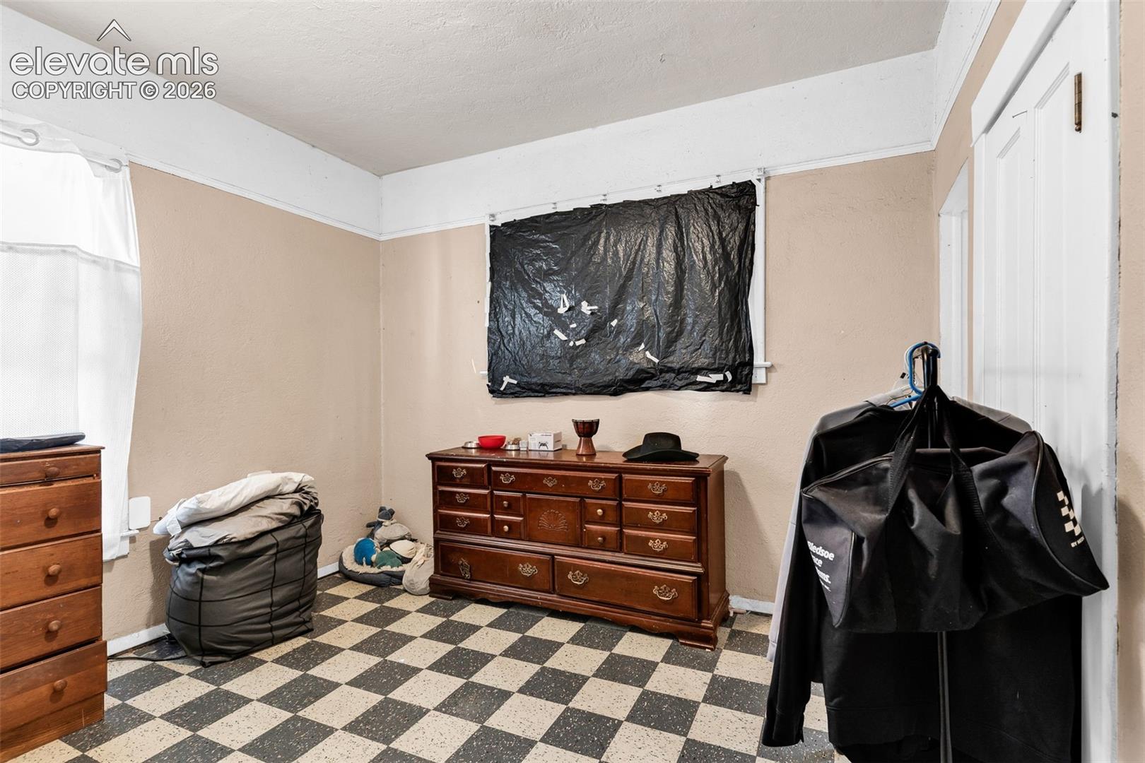 Checkered floor tiling, neutral wall tones, and white trim