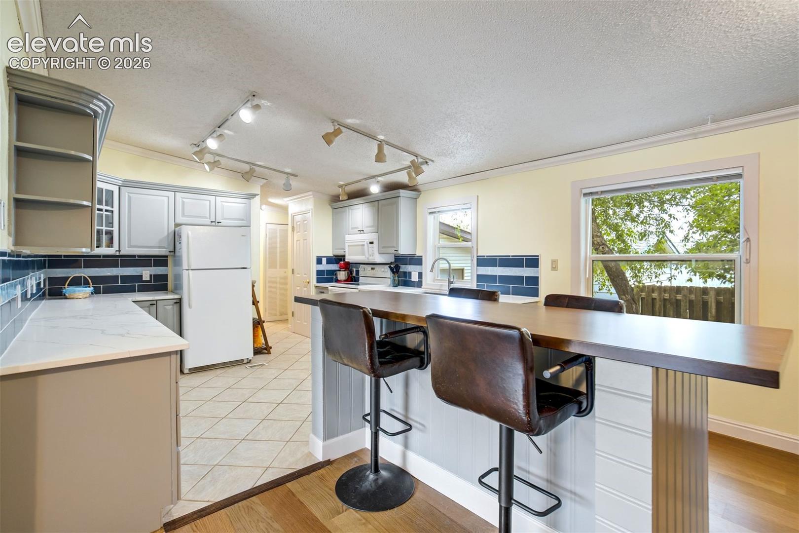 Large center island made from solid wood butcher block provides additional seating and workspace.