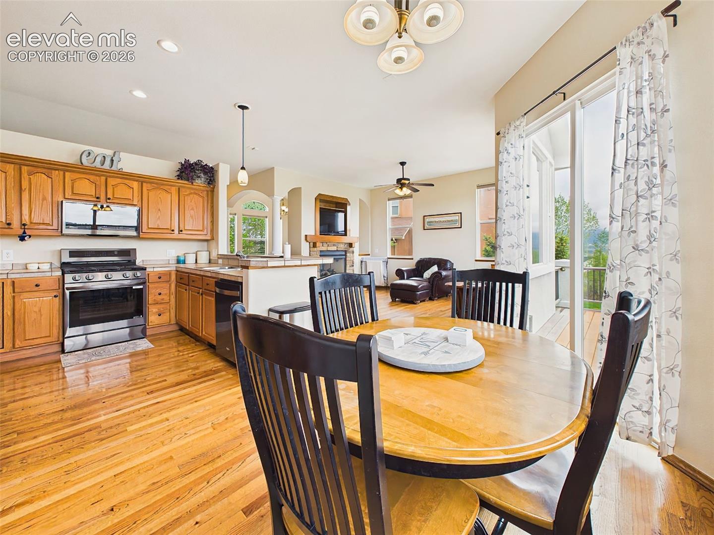 Open kitchen and dining space with hardwood floors, easy deck access, and seamless flow into the adjoining family room.