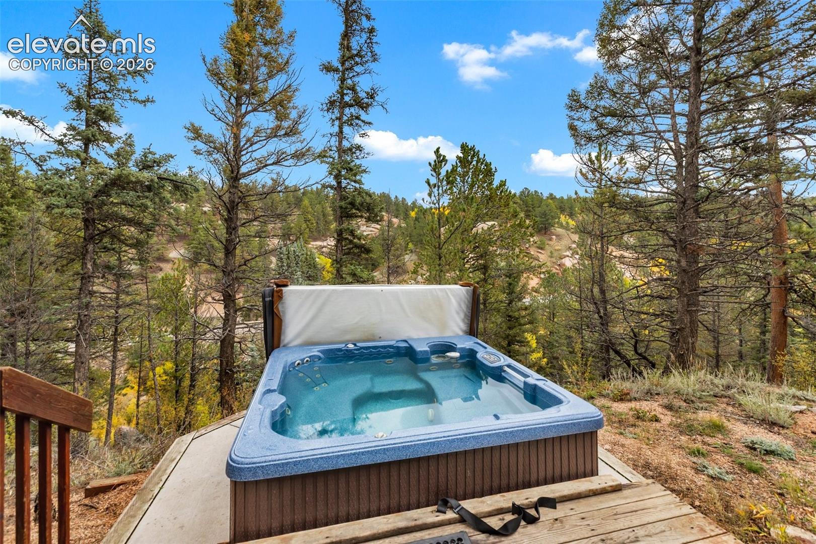 Outdoor hot tub with wood paneling and a surrounding wood deck