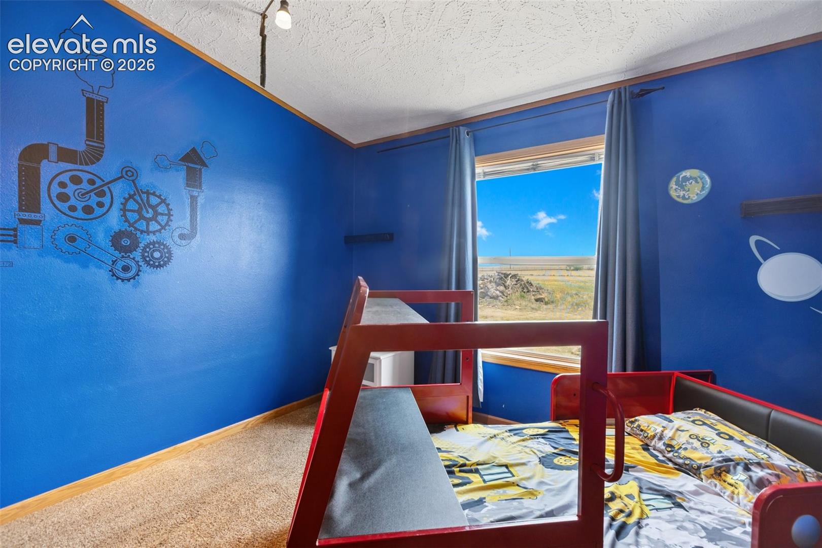 3rd bdrm carpeted room with blue walls, a window featuring an expansive sky, and built-in shelving