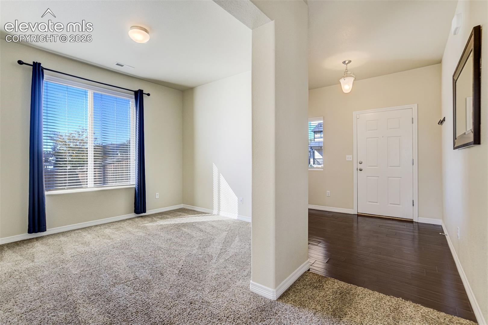 Hardwood-finish flooring, recessed lighting, neutral wall tones, and a paneled entry door