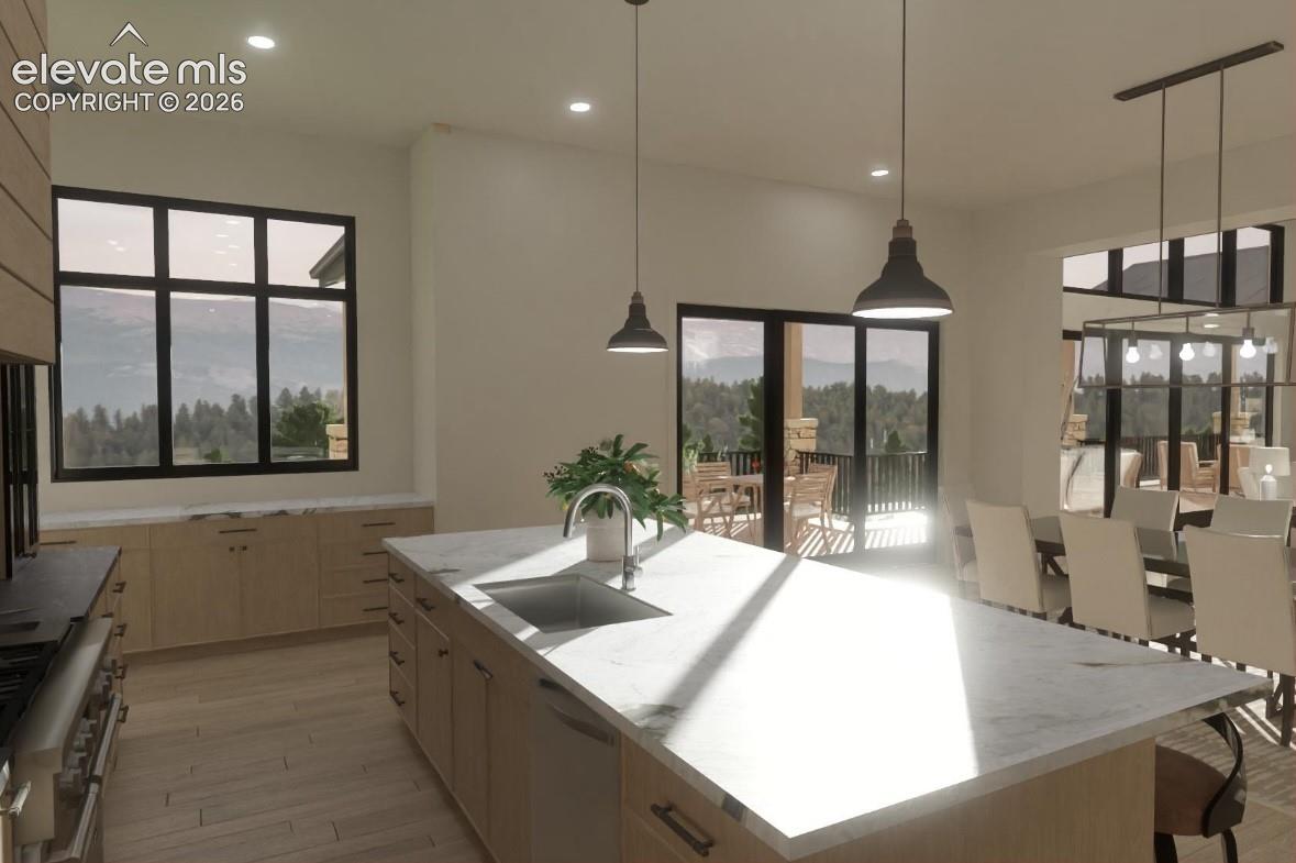 Spacious kitchen featuring a large central island with an undermount sink, light-toned cabinetry, and recessed lighting
