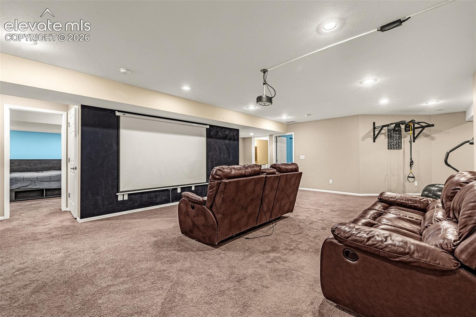 Recessed lighting, projector screen, wall-mounted projector, and carpeted flooring