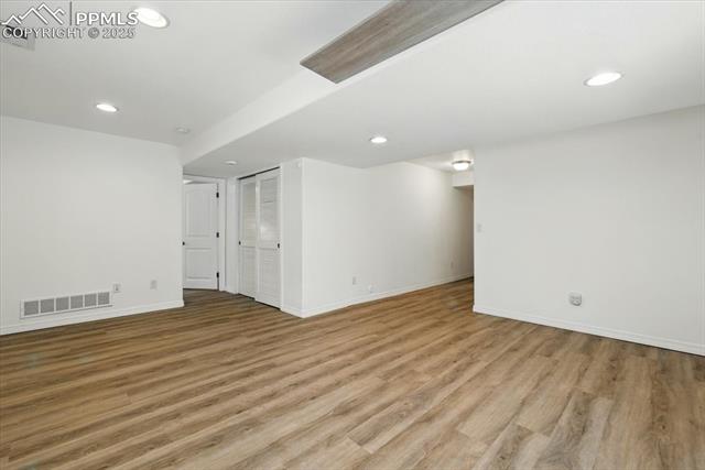 Empty room with baseboards, light wood-style flooring, and recessed lighting