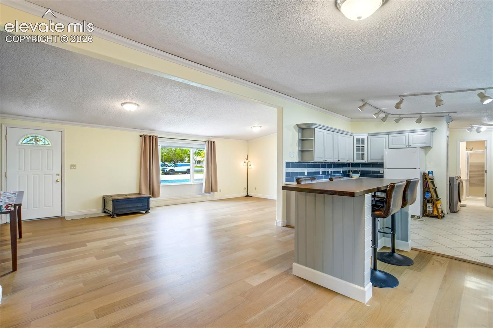 Updated cabinetry, track lighting, and bar seating add both function and style to the space.