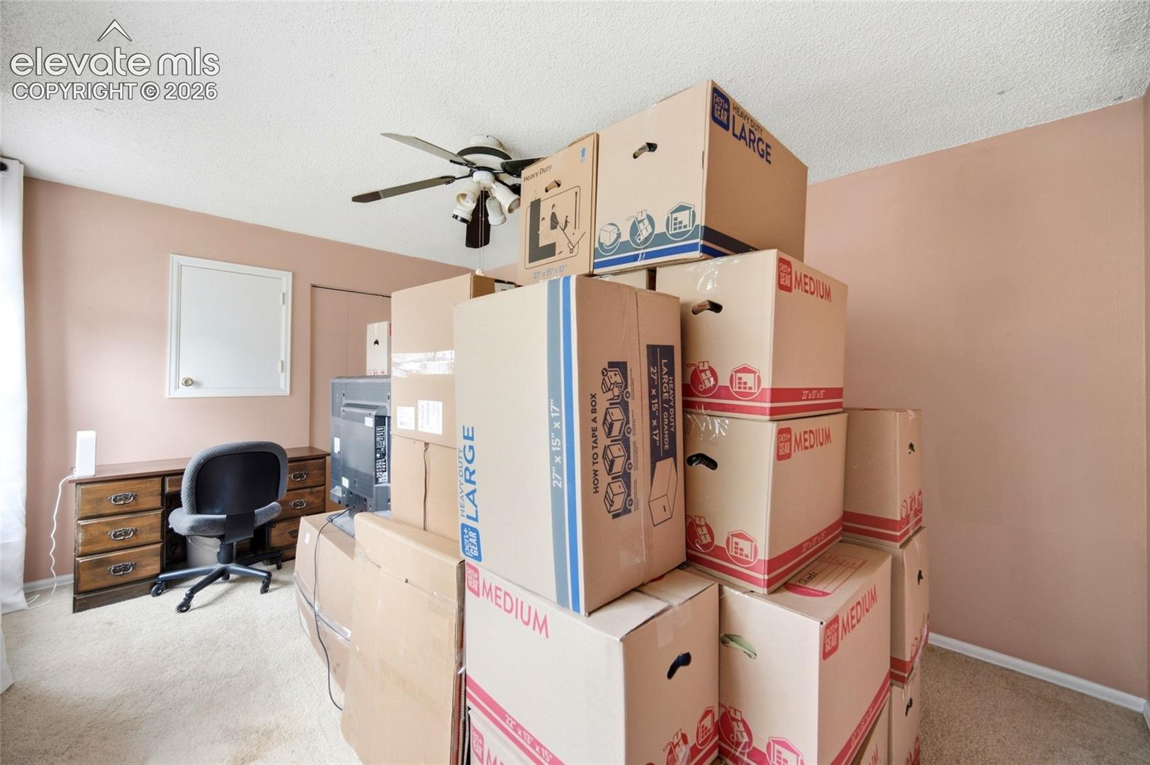 Spacious upper-level bedroom with celling fan. 