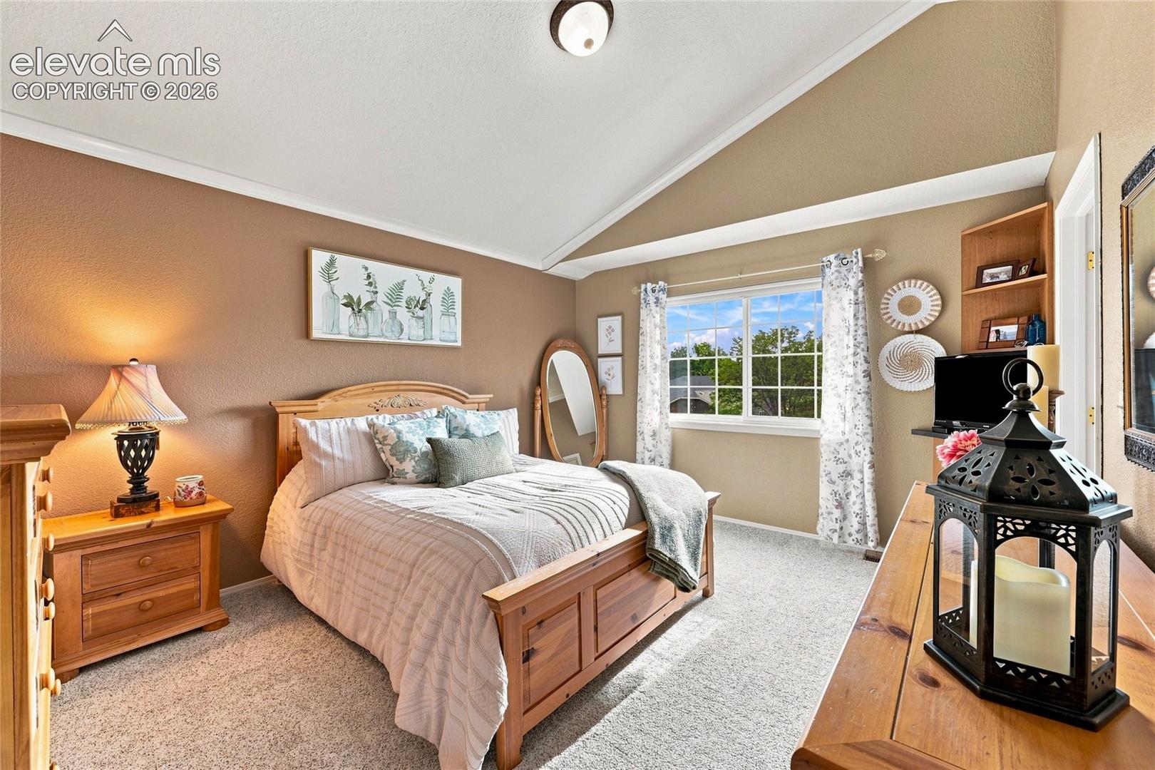Primary bedroom with vaulted ceiling