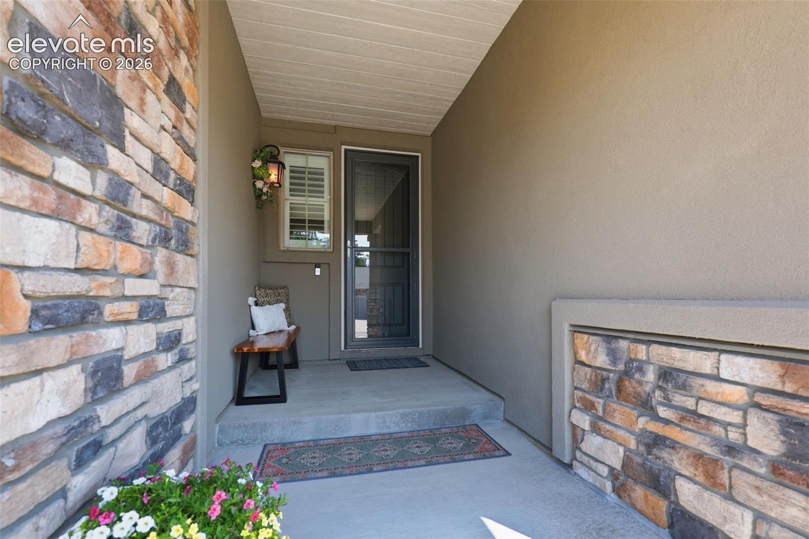 Stone veneer and stucco exterior with a covered entry.