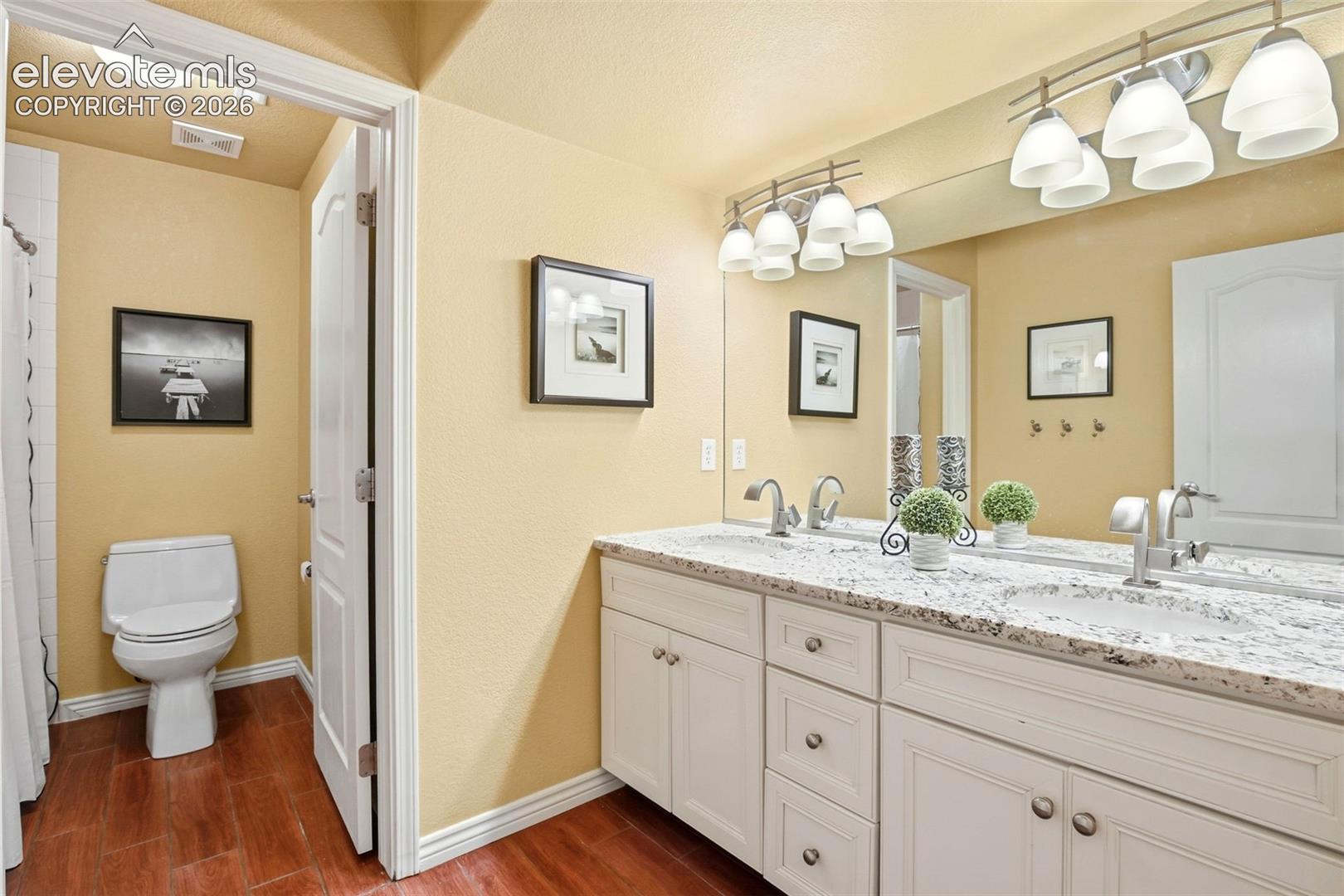 A bright basement bathroom, with double sink vanity and a separate toilet and shower are for added privacy.