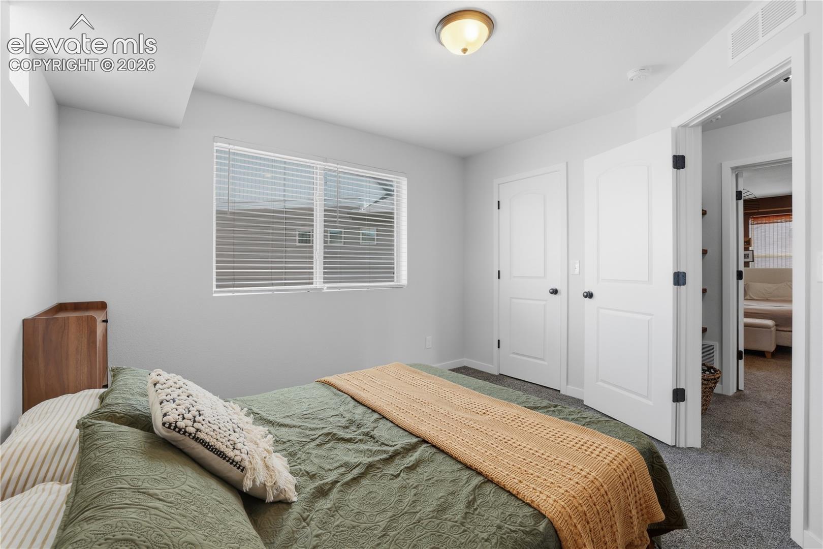 Bedroom featuring light gray walls, white trim, and gray carpet