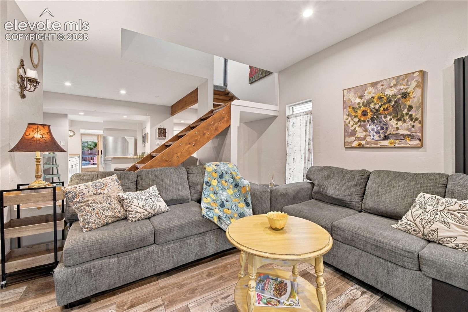 Wood-finish flooring, recessed lighting, and a prominent open staircase with wooden treads