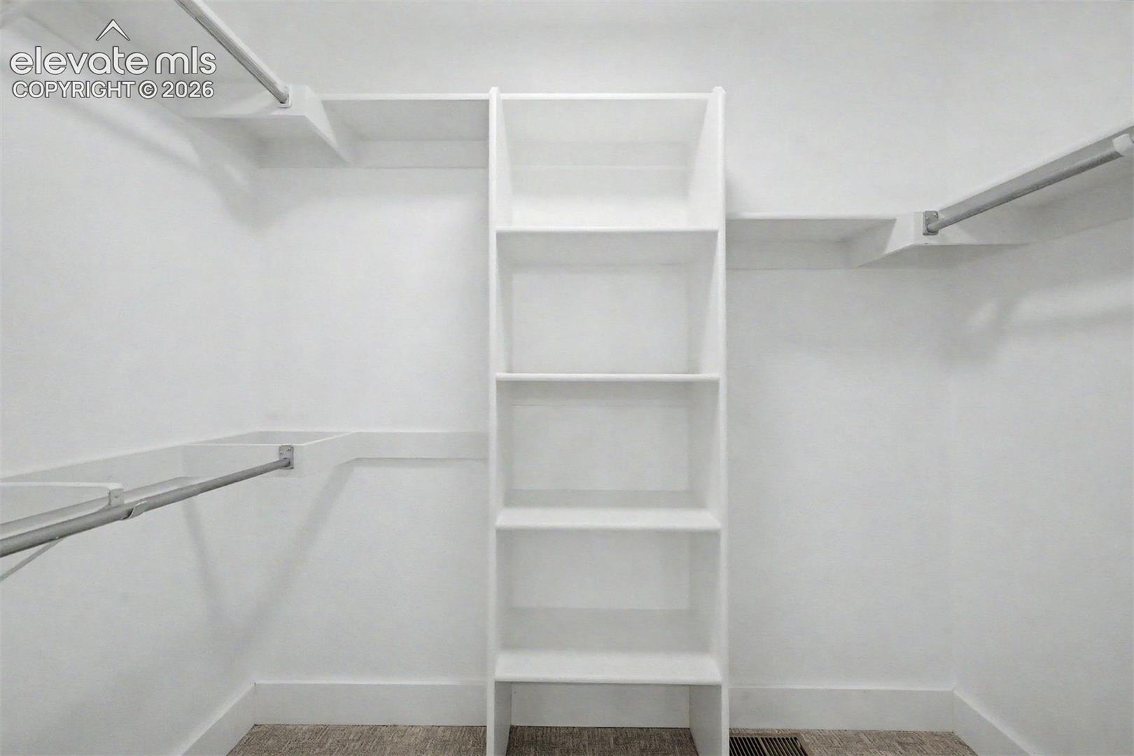 Primary walk in closet with storage