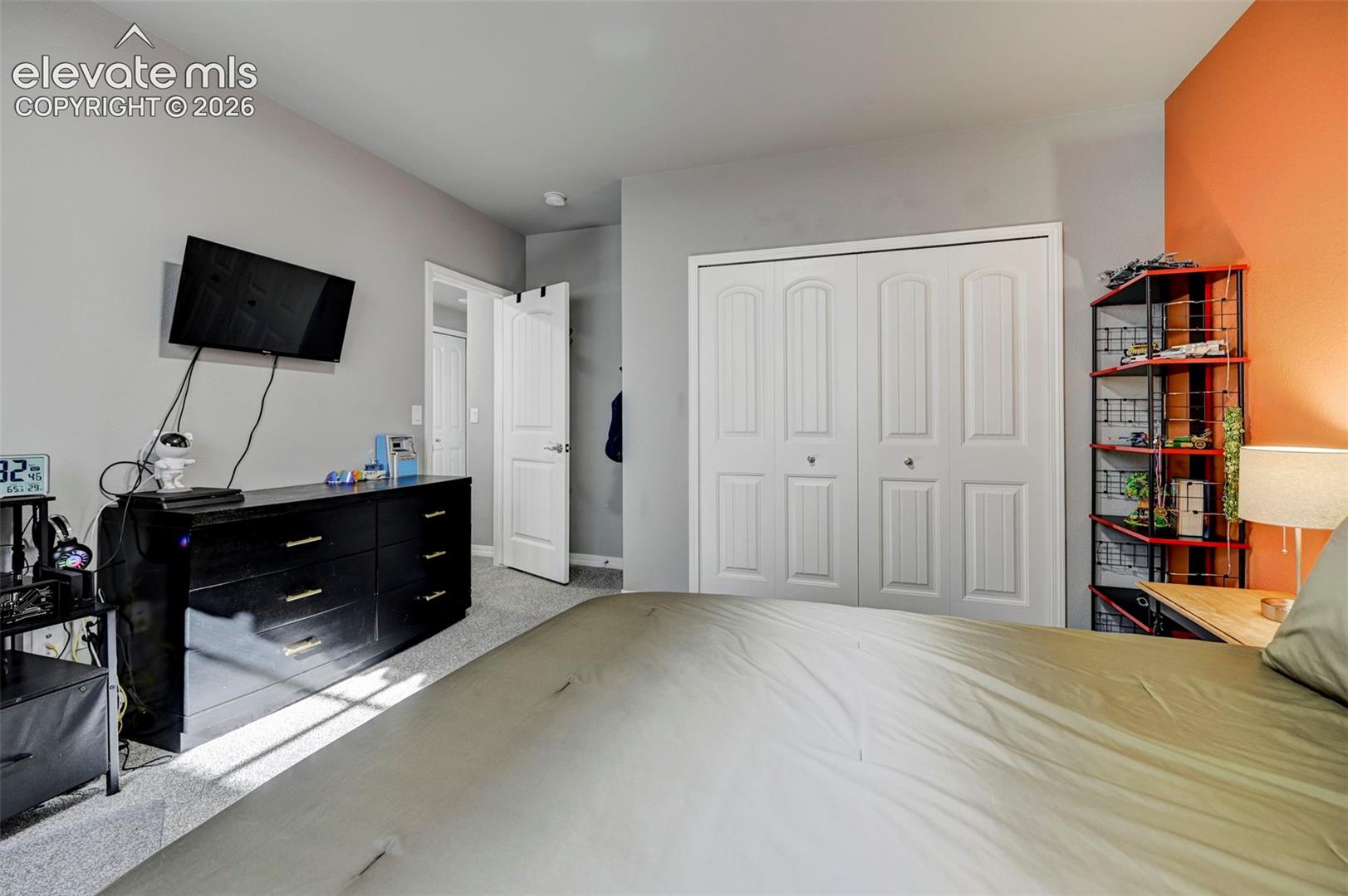 Plush carpeting throughout with a two-panel bifold closet door, and a six-panel interior door