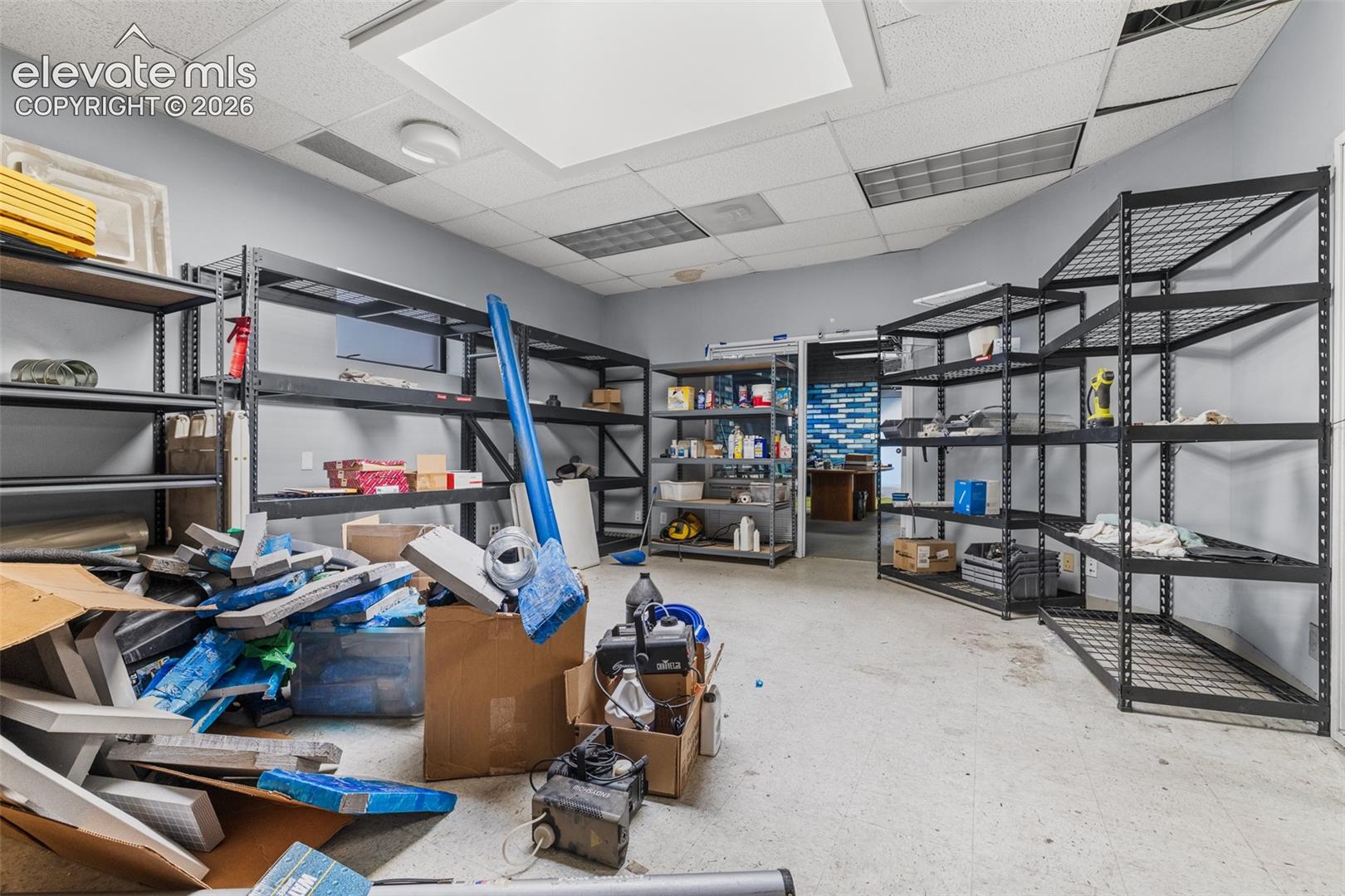 Enclosed utility space featuring a drop ceiling with recessed lighting and neutral wall paint