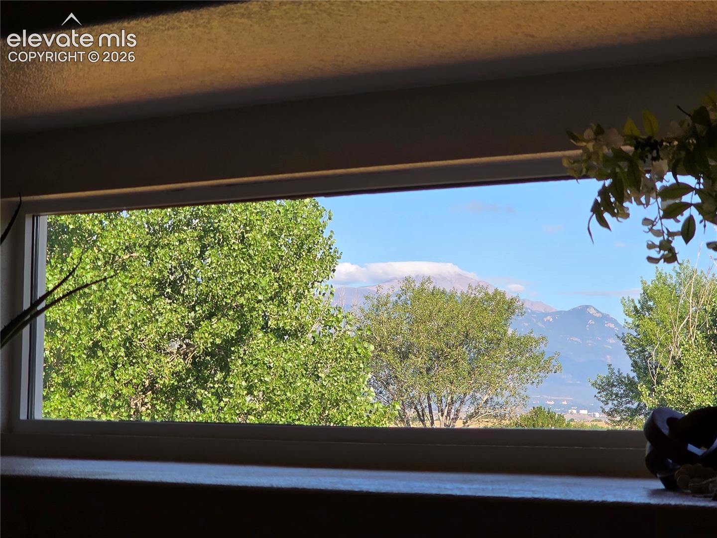 Seller Provided Photo of View of Pikes Peak through Living Room Picture Frame Window