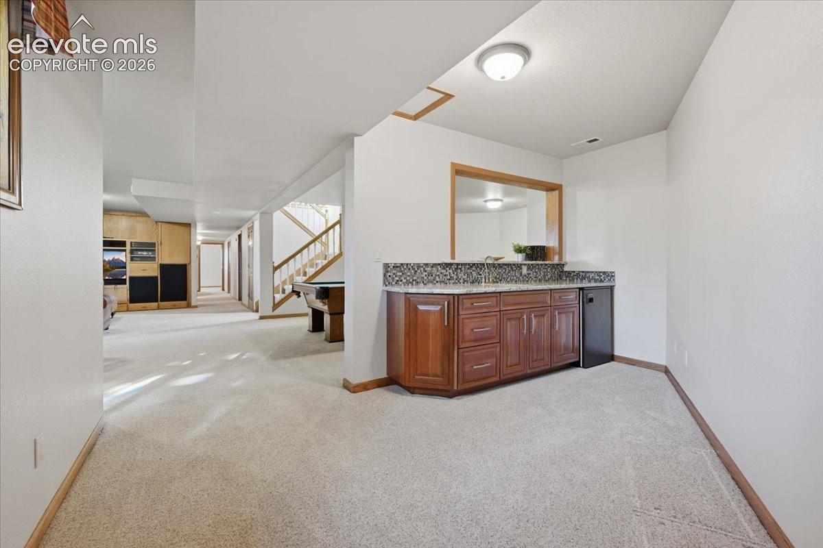 Wet bar featuring mini-fridge. 