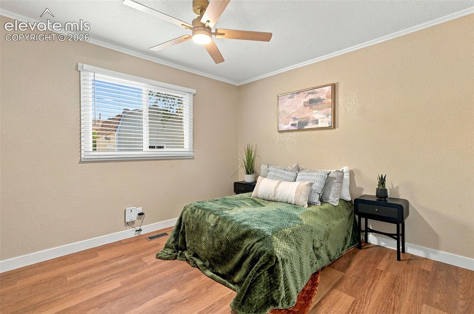 Wood-finish flooring, ceiling fan with integrated lighting, and horizontal window blinds