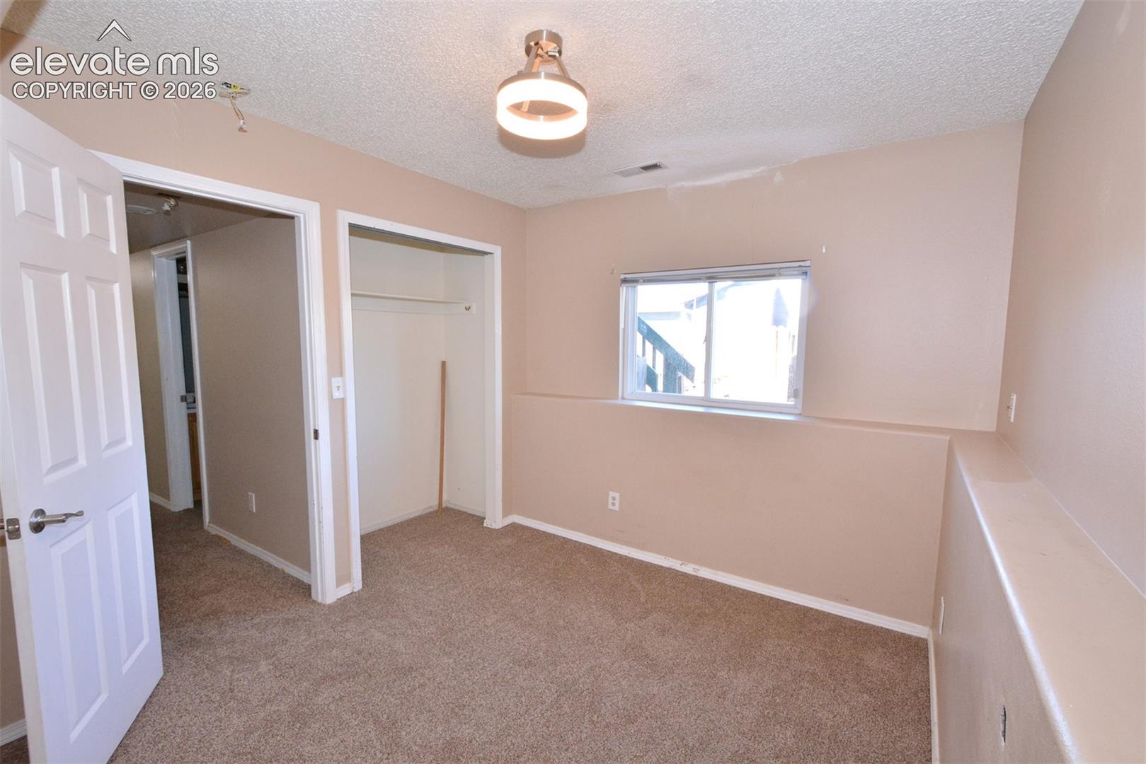 Carpeted flooring, window with blinds, recessed closet, and a semi-flush mount ceiling light fixture