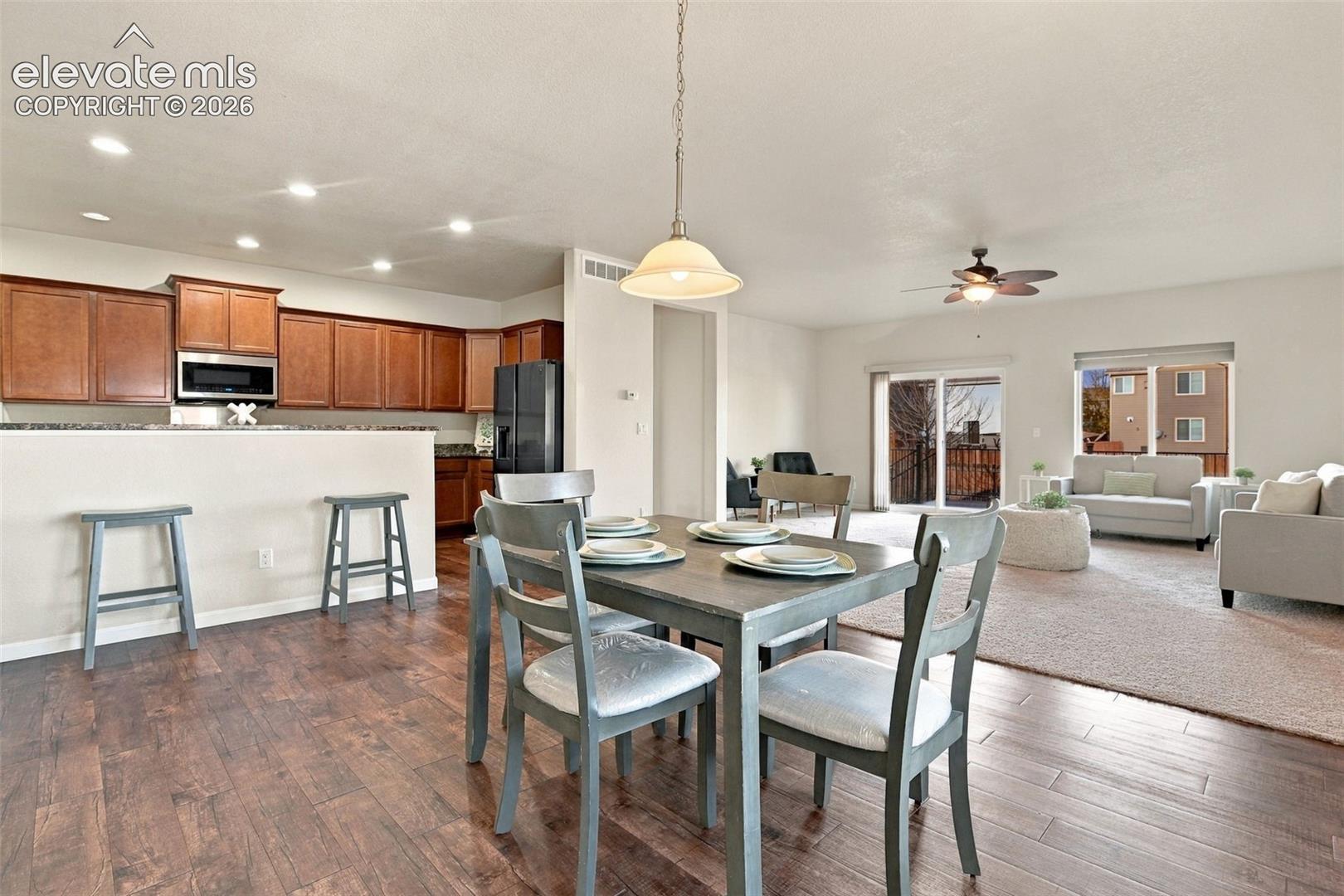 Kitchen featuring dark wood-finish cabinetry, a breakfast bar, recessed lighting, and wood-finish flooring