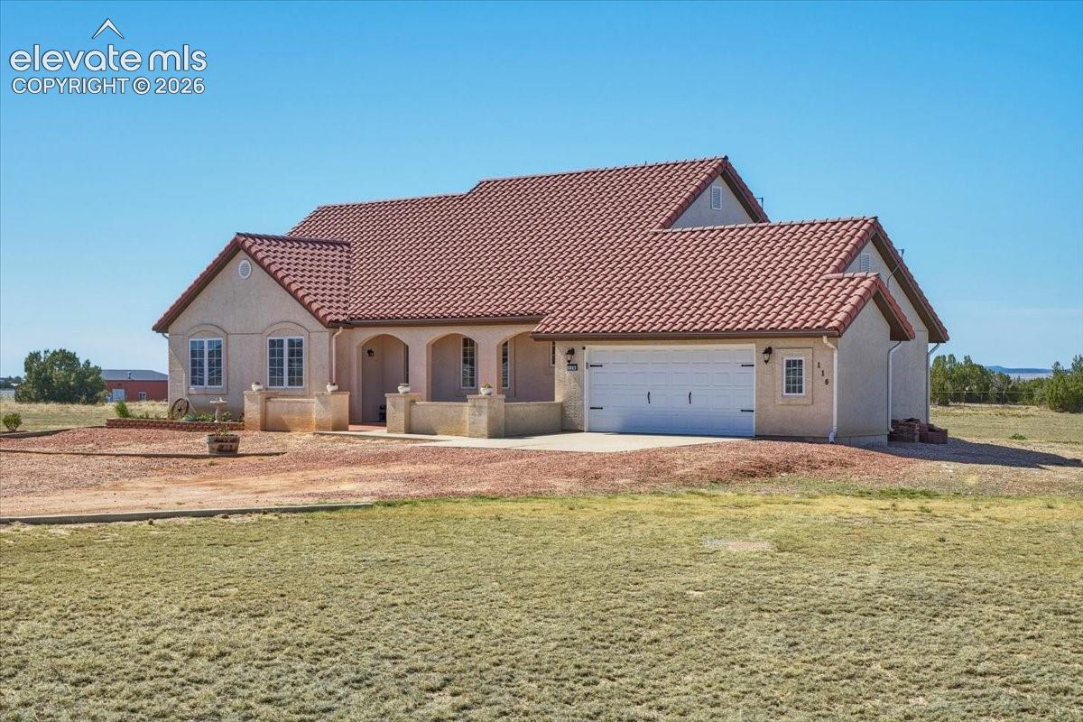 Spacious oversized garage featuring custom workbenches, extensive storage, bright lighting, and durable flooring for projects, hobbies, or vehicle storage.