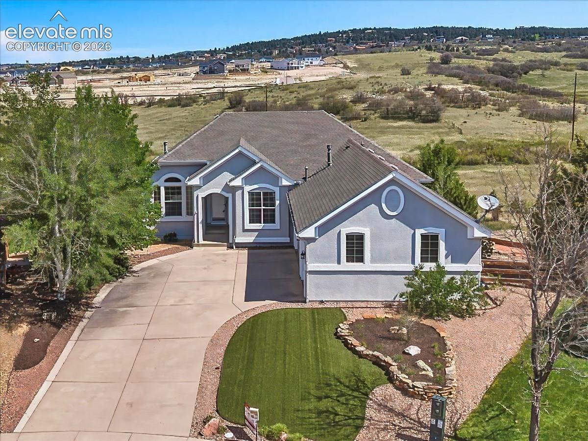 Attractive stucco exterior with new exterior paint, mature landscaping, an oversized driveway, and a spacious three-car garage.