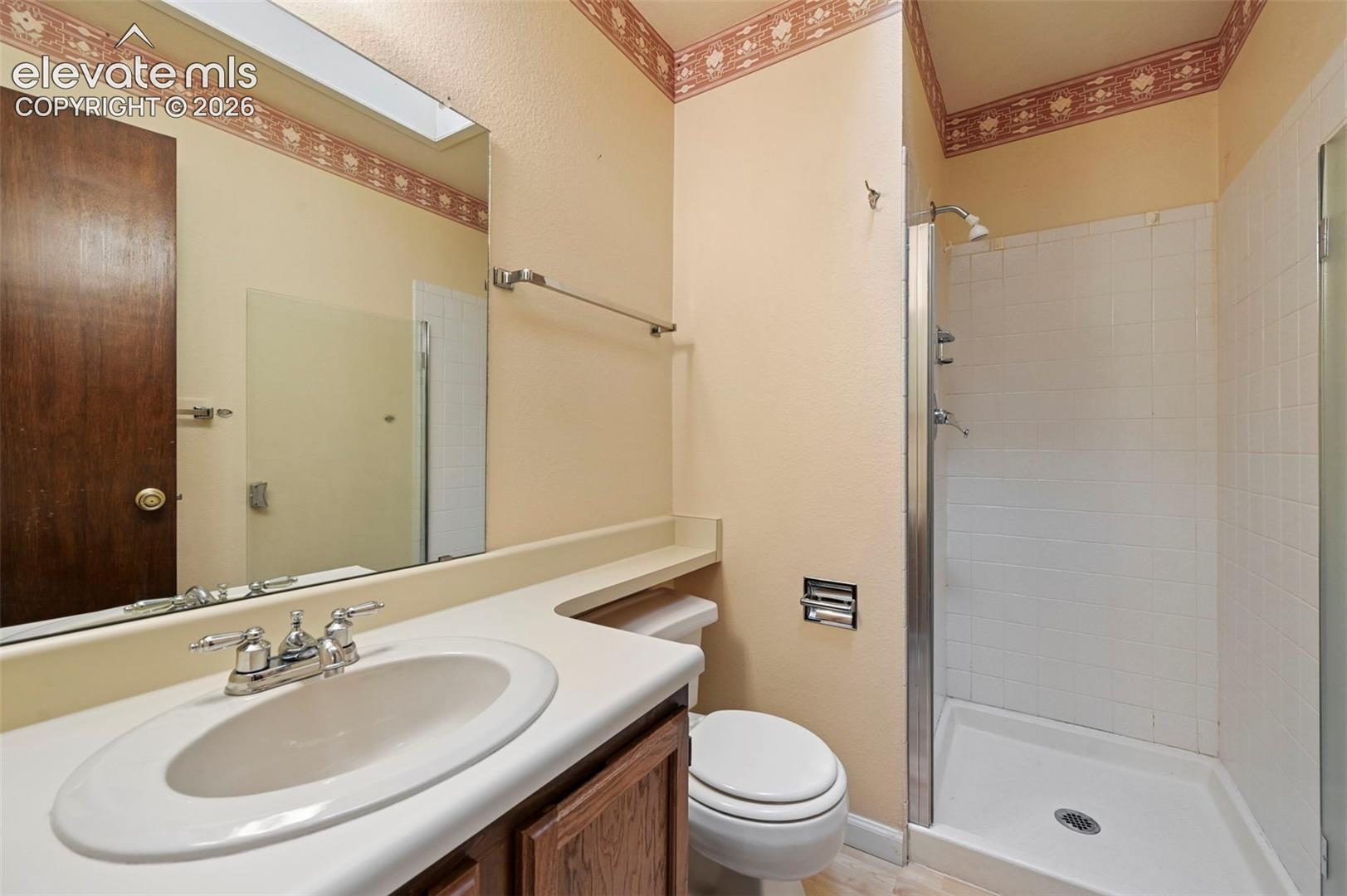 Bathroom with enclosed shower with white tile surround